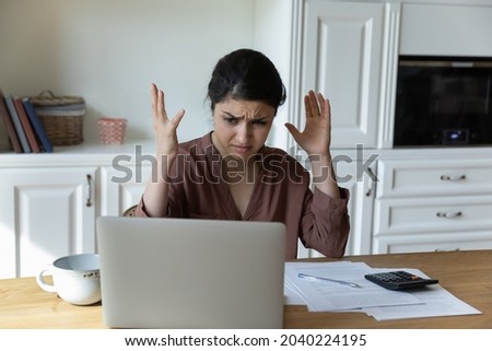Financial problem. Worried shocked indian female entrepreneur sit by laptop find out overdue tax account unexpected debt. Frustrated young mixed race woman unable to pay bills online becoming bankrupt Royalty-Free Stock Photo #2040224195