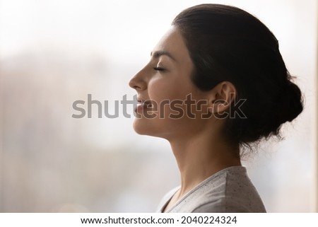 Meditation. Side profile shot of happy serene young indian female face. Calm millennial ethnic lady breath deep with closed eyes meditate feel zen good harmony peace of mind practice yoga meet new day Royalty-Free Stock Photo #2040224324