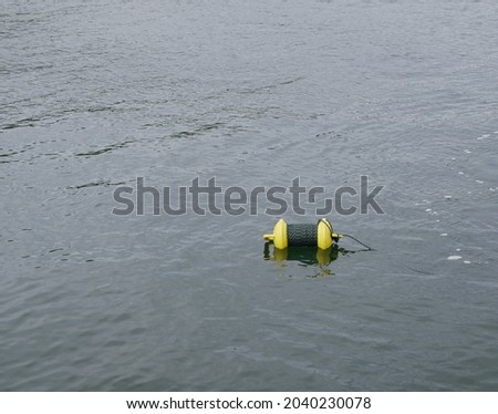 Equipment for technodiving. A yellow plastic marking buoy with a multi-colored rope wrapped around. A bright yellow buoy on the surface of the water indicates the place of work of the drivers.