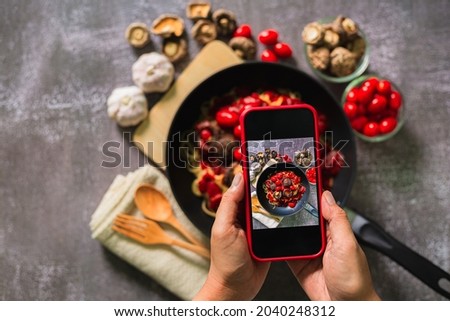 Take a photo of spaghetti with a mobile phone,Top view of woman taking photo on dishes