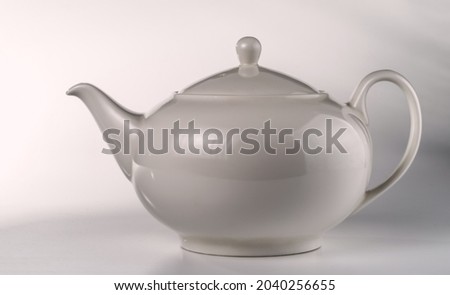 Light gray ceramic teapot on a light background. 