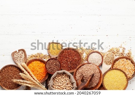Gluten free cereals. Rice, buckwheat, corn groats, quinoa and millet in wooden bowls. Top view flat lay with copy space Royalty-Free Stock Photo #2040267059