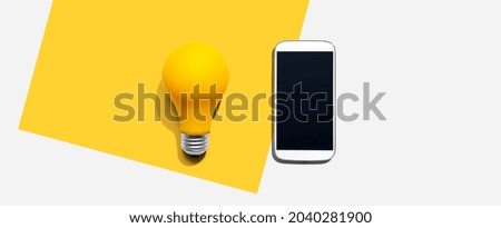 Smartphone with a yellow light bulb from above