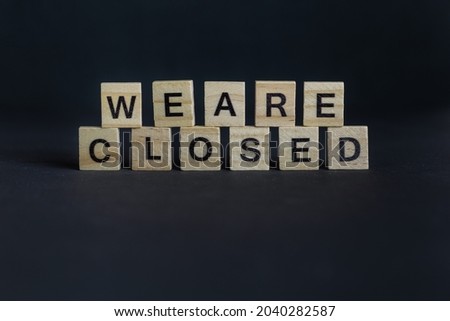 we are closed lettering from wooden letters placed on top of each other in the center of the picture in front of black background