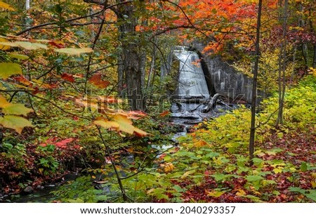 Manmade water falls in surrounded  with fall foliage in Michigan upper peninsula