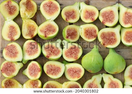 Background of many freshly sliced ​​figs lying next to each other on an old wooden box