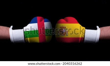Two hands of wearing boxing gloves with Spain and Central African Republic flag. Boxing competition concept. Confrontation between two countries