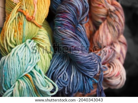 Diversified cotton yarn for knitting. Hand-dyed threads. Modern tie dye. Craft and hobby. Multicolored background