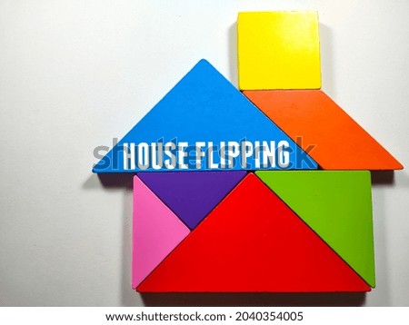 Business concept.Text HOUSE FLIPPING with colored tangram on a white background