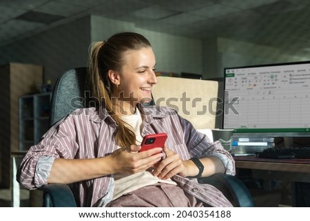 natural portrait of a young woman communicates on the phone in the office in a great mood