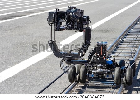 A trolley with video camera on rails. Camera trolley with camera. Cinematography equipment. Concept - rent of operator equipment. Equipment for video filming. Rail trolley for operator.