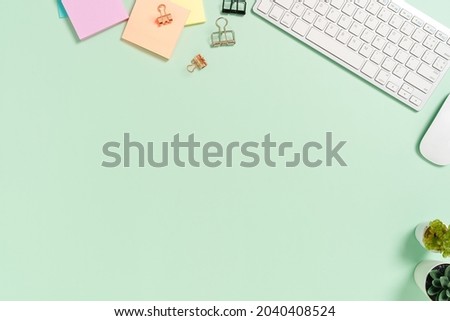 Minimal work space - Creative flat lay photo of workspace desk. Top view office desk with keyboard, mouse and book on pastel green color background. Top view with copy space, flat lay photography.