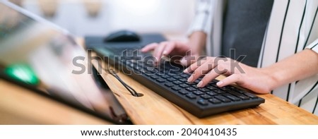 close up female hand working typing keyboard information with monitor screen device,business owner adding data for analysis business strategy ideas concept