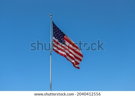 The American flag with a deep blue sky background.