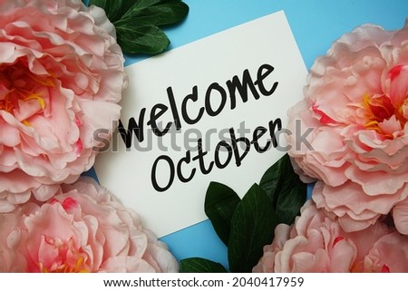 Welcome October typography text with peony flowers on blue background