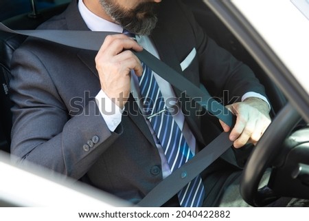 Business man hand fastening seat belt in car. Safety first concept. Royalty-Free Stock Photo #2040422882