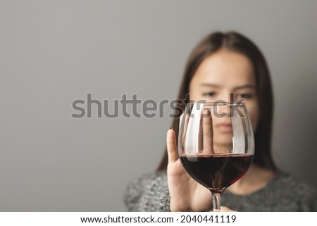 abstinence alcohol, stop liquor, teenager shows a sign of rejection of wine with her hand, refusal of alcoholism of minors Royalty-Free Stock Photo #2040441119