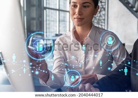 Businessman and businesswoman in formal wear working together looking for new employees to hire for international business consulting. HR, social media icons over modern panoramic office background