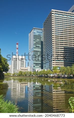 Skyscrapers of Marunouchi commercial district reflecting in the water of Tokyo Imperial palace outer moat. Tokyo. Japan
