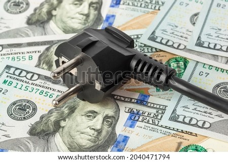 Electric plug on money - business technology background