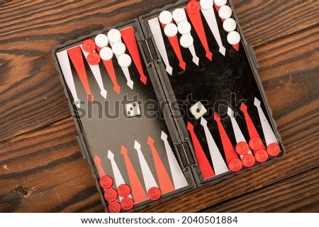 Backgammon board with chips and dice on a wooden table, close-up, selective focus