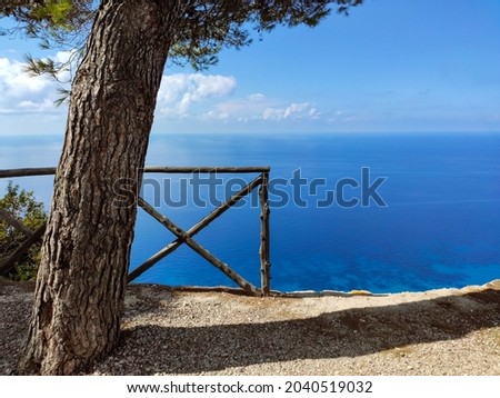 Egremni Beach Panorama observation deck with pine tree. Sunny view on sea turquoise water and scenic blue sky, Lefkada island, Ionian sea coast, Greece