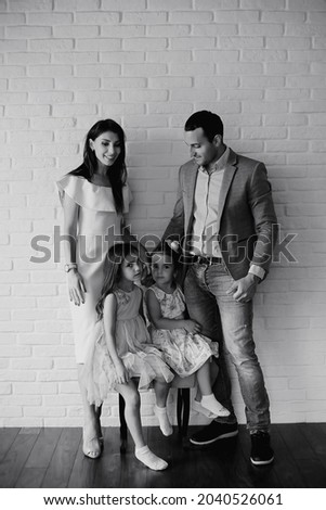 Beautiful young family with daughters at a photo shoot in a white studio