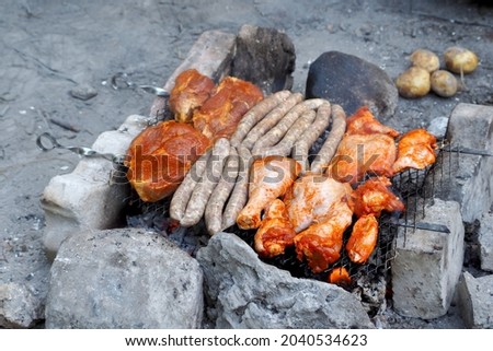 cooking chicken marinated in tomato sauce with paprika, lying on the grill, side view. outdoor food