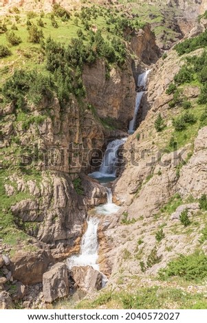 Beautiful waterfall cascade in the mountains landscape during sunset. Adventure travel concept. Wallpaper background nature print.
