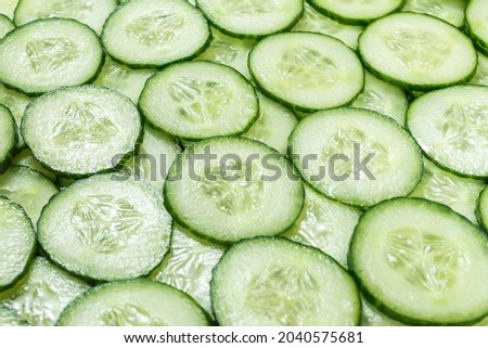 Fresh green slices of cucumber as background. Top view. 