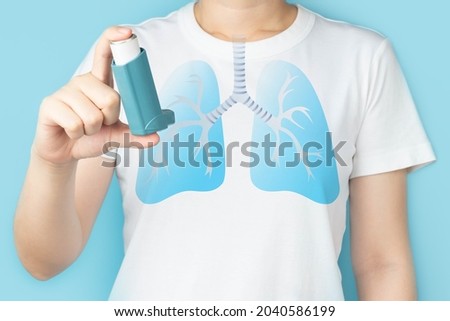 Young woman using blue asthma inhaler for relief asthma attack. Pharmaceutical products is used to prevent and treat wheezing and shortness of breath caused asthma or COPD. Lung organ anatomy. Royalty-Free Stock Photo #2040586199