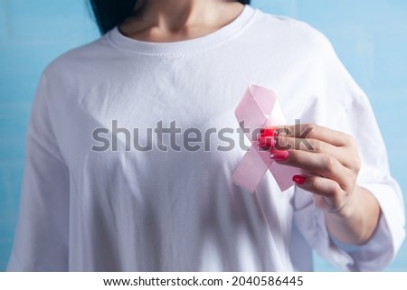 young girl holding a pink ribbon