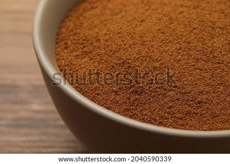 Bowl of chicory powder on wooden table, closeup