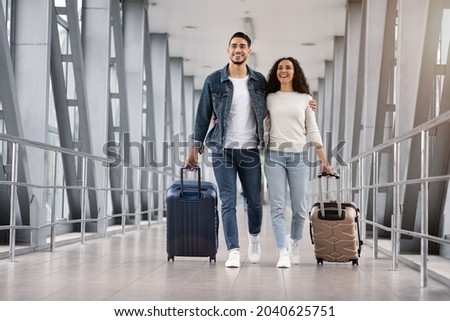 Ready For Vacation. Romantic Middle Eastern Couple Walking With Suitcases At Airport Terminal, Happy Arab Spouses Embracing While Going To Boarding Gate, Enjoying Travelling Together, Copy Space Royalty-Free Stock Photo #2040625751
