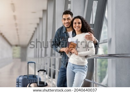 Vacation Trip. Happy Arab Spouses Posing In Airport Terminal, Cheerful Middle Eastern Travellers Couple Waiting For Flight, Looking At Camera And Smiling, Enjoying Travelling Together, Free Space Royalty-Free Stock Photo #2040640037