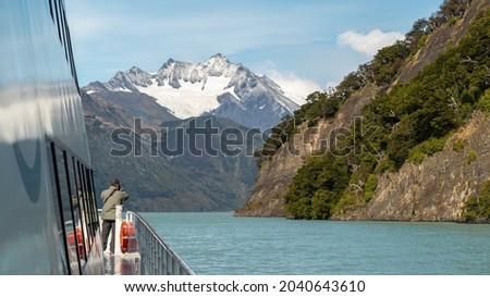 Beautiful mountains of Patagonia, tourists sailing on an excursion taking photos 