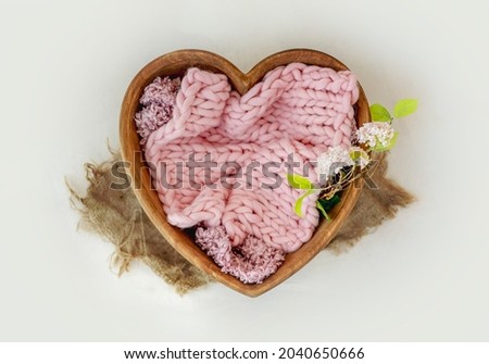 Wooden bed heart decor for newborn studio photoshoot with knitted blanket closeup