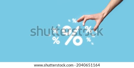 Male hand holding interest rate percent icon on blue background. Interest rate financial and mortgage rates concept.Banner with copy space.