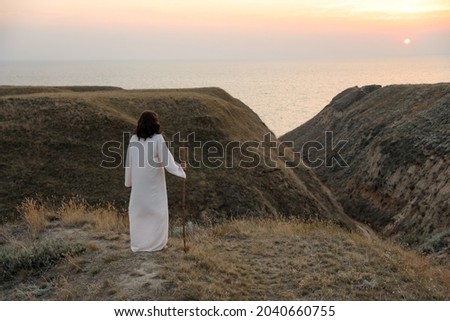 Jesus Christ on hills at sunset, back view. Space for text Royalty-Free Stock Photo #2040660755