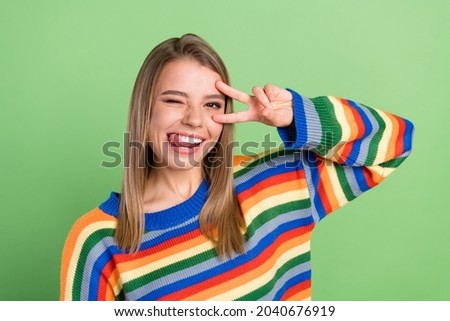 Photo portrait smiling girl showing v-sign gesture licking lips isolated pastel green color background