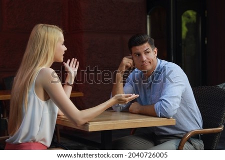 Man having boring date with talkative woman in cafe Royalty-Free Stock Photo #2040726005