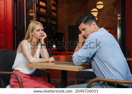 Bored couple having unsuccessful date in cafe Royalty-Free Stock Photo #2040726011