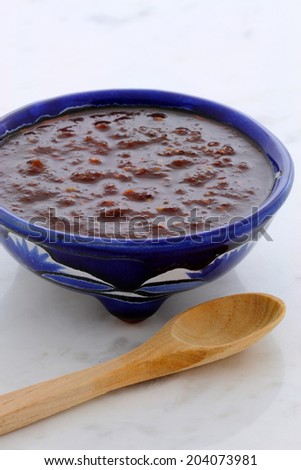Artisan mexican hot salsa in vintage talavera bowl, with a delicious fresh hot flavor,  on vintage carrara marble table.