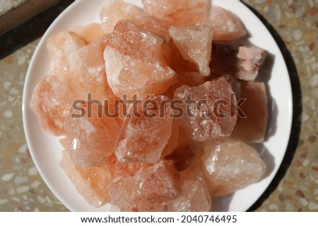 Pink Himalayan salt blocks on white plate on a floor