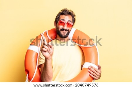 expressive crazy man smiling and looking friendly, showing number one. life guard concept