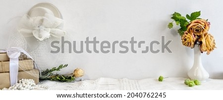Fashionable white stock background with a blank photo frame and flowers. Blank for a postcard. Female wedding background.
