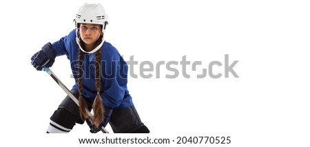 Cropped portrait of young girl hockey player in blue uniform stading in defense pose and drilling tricks. Competition training exercises. Concept of sport healthy lifestyle, hobby. Copy space for ad