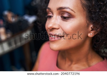 Dreamy brunette female person enjoying her makeup