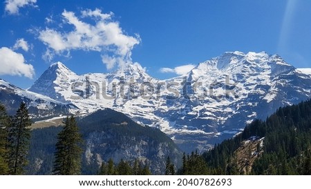 Swiss snow covered mountains Jungfrau, Eiger and Monch on a sunny day Royalty-Free Stock Photo #2040782693
