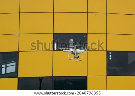 Quadcopter Drone Flying front a Yellow Building in Medellin, Colombia